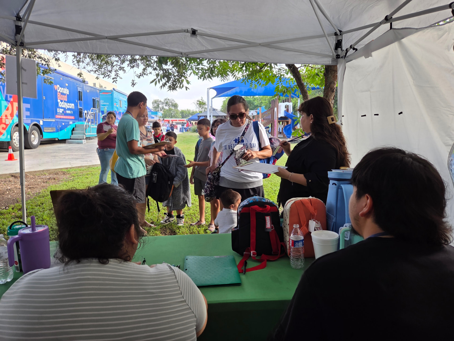 Phenomenon210 volunteers handing out backpacks to families at a community event in San Antonio